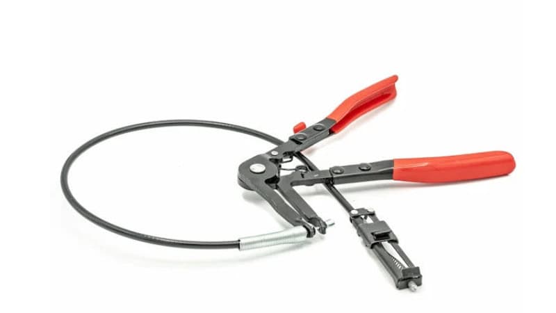 Hose clamp pliers compressing a spring clamp in an automotive engine bay