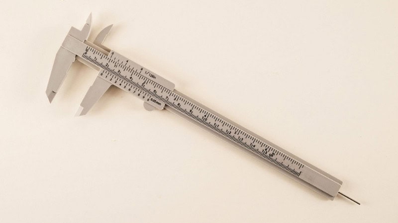 Vernier caliper used by machinist to measure outside diameter of metal component